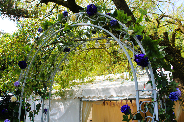 Archway with artificial garlands & purple and cream flowers