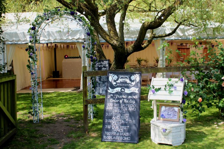 Flower arch as decorative entrance to wedding marquee